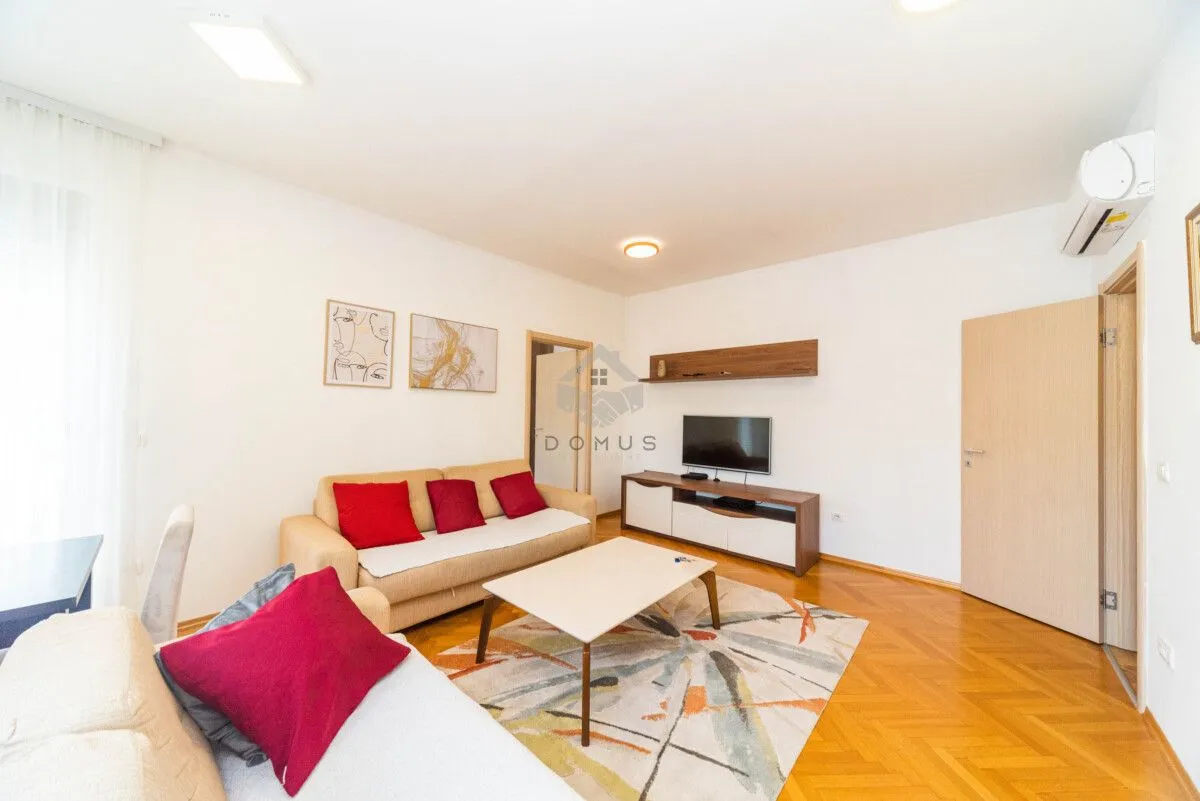 Living room with sofa, coffee table and television.