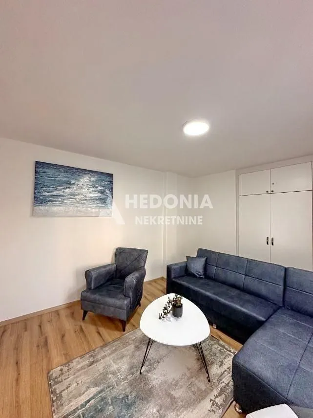 Udobna dnevna soba sa garniturom za sedenje i stočićem.