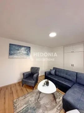 Udobna dnevna soba sa garniturom za sedenje i stočićem. - image 4