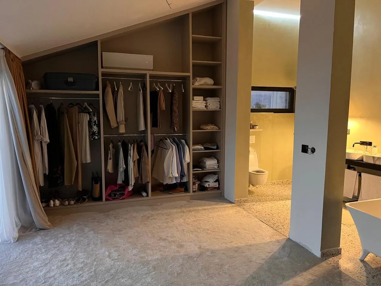Bedroom with a built-in wardrobe and an open view of the bathroom.