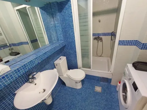 Kupatilo sa plavim mozaik pločicama, tuš kabinom, umivaonikom i veš mašinom. - image 6