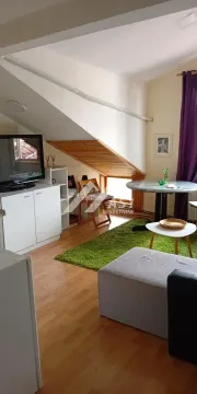 Potkrovni dnevni boravak sa TV komodom, trpezarijskim stolom i kosim plafonom. - image 4