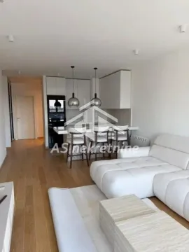 Modern living room with a sectional sofa and kitchen in the background. - image 3