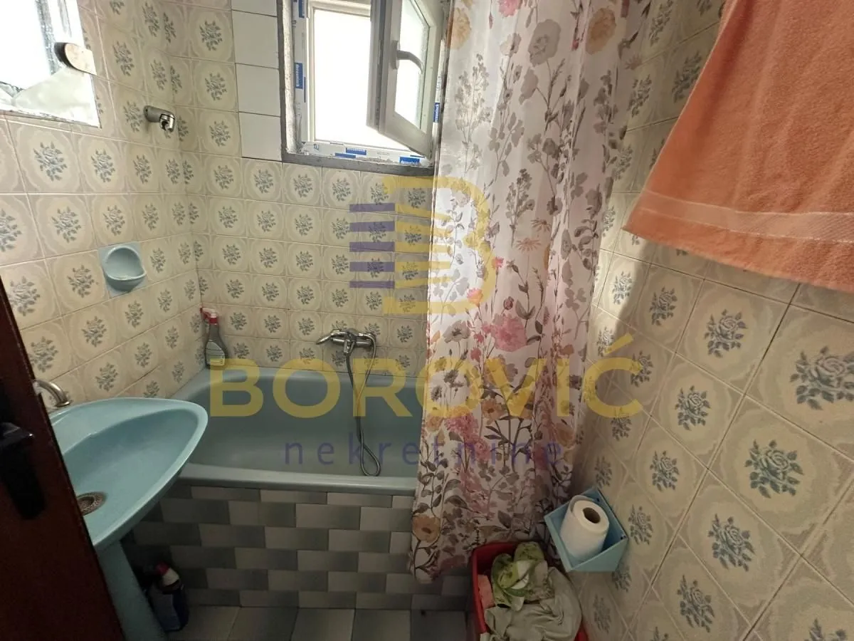 Manje kupatilo sa kadom i pločicama sa uzorkom.