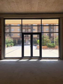 View through a large glass wall towards the courtyard and surrounding buildings in a new construction. - image 5