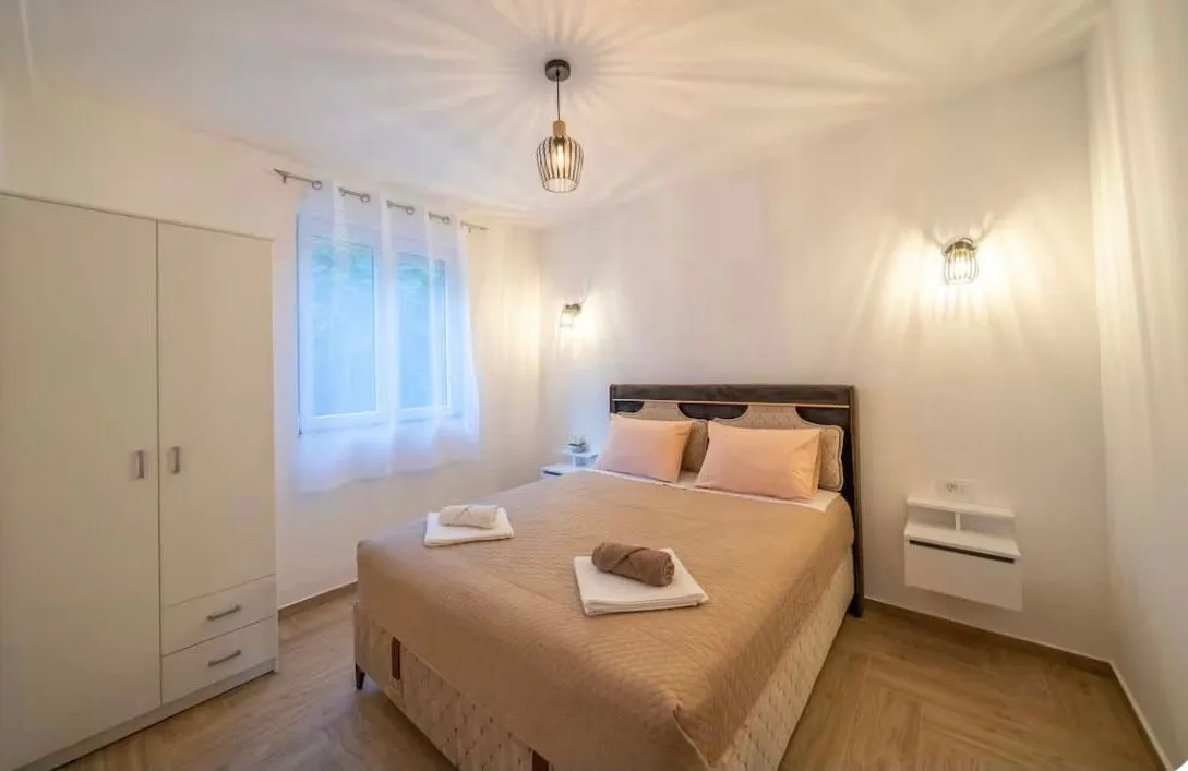 Bright bedroom featuring a double bed and a white wardrobe.