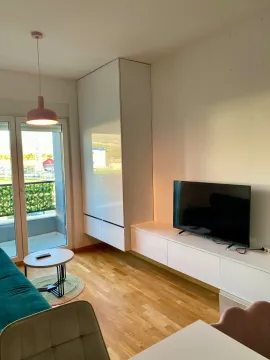 Dnevna soba sa garniturom, televizorom i izlazom na terasu. - image 2
