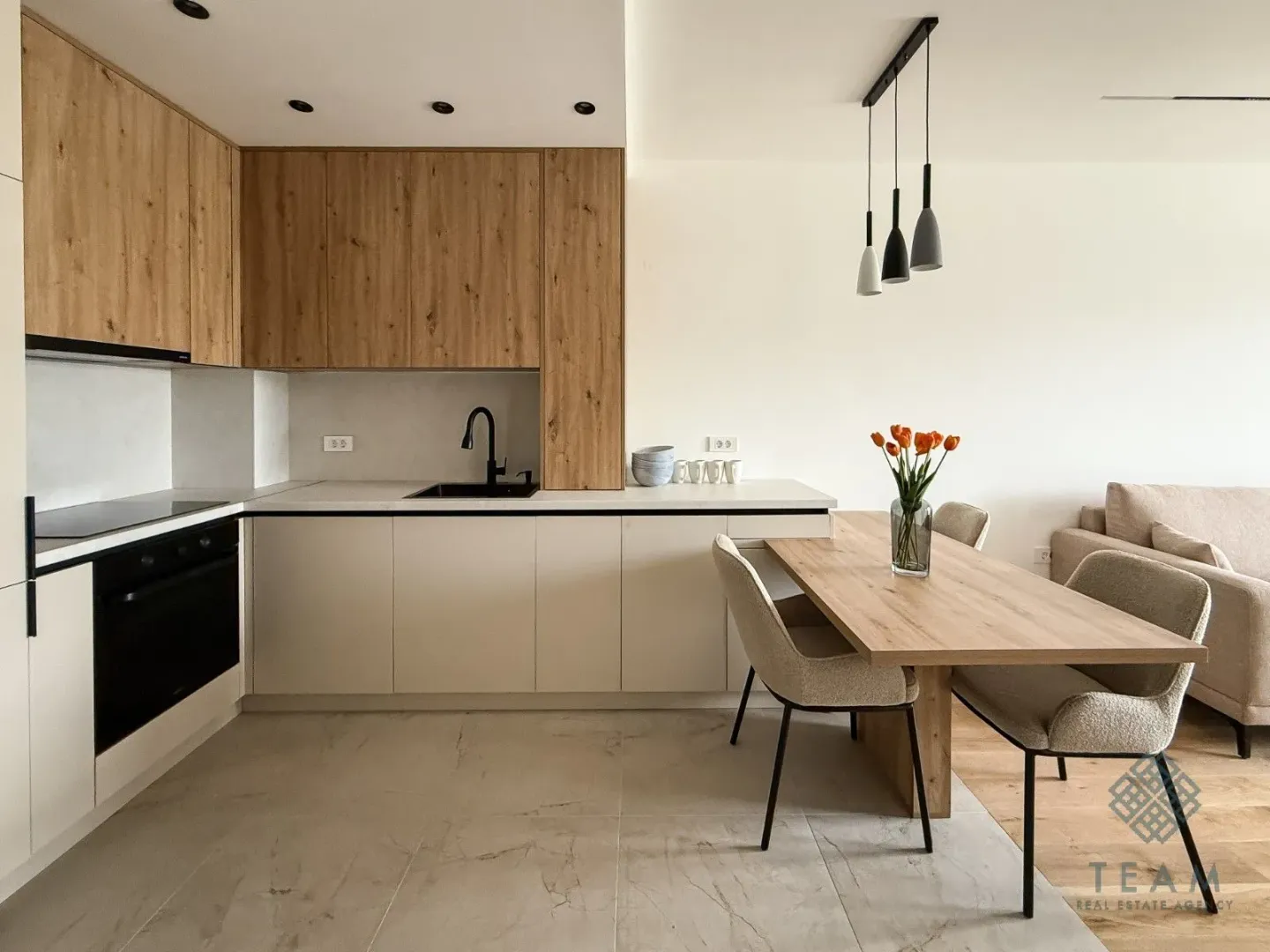 Modern kitchen with wooden elements and a dining area.