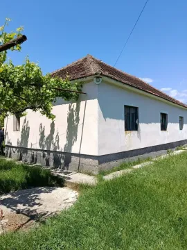Pogled na spoljašnjost starije kuće sa travnjakom. - image 10