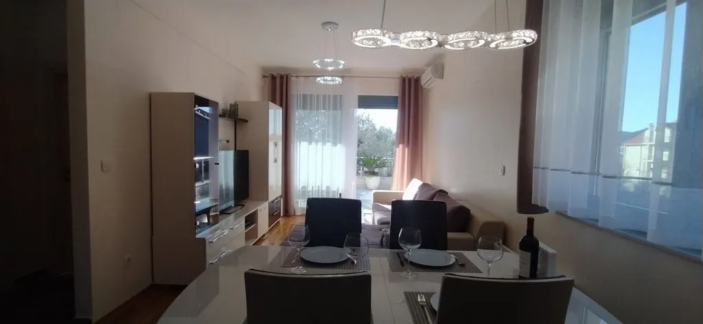 Svijetla dnevna soba sa trpezarijom i izlazom na terasu.