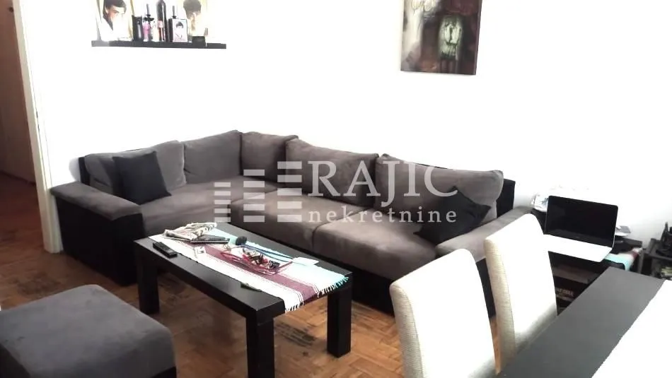 Living room with a corner sofa and dining table.