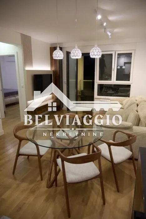 Living room with dining area, sofa and TV.
