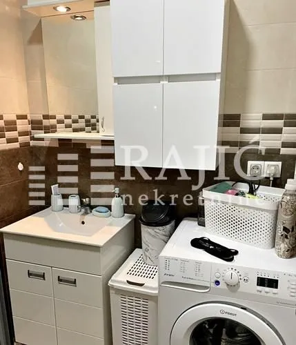 Small bathroom with a sink, cabinet, and washing machine.