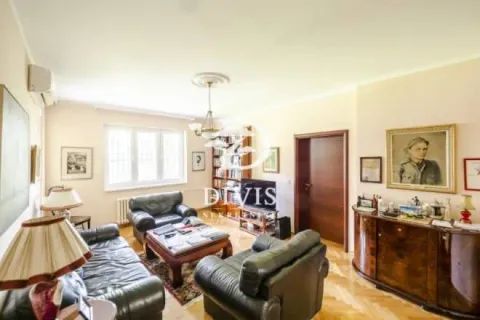 Spacious living room with seating furniture, bookshelves, and a TV. - image 14