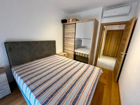 Furnished bedroom with a double bed, wardrobe, and air conditioning. - image 7