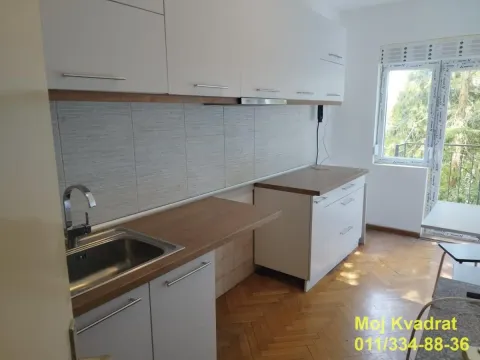 Empty kitchen with white units and a wooden countertop. - image 5