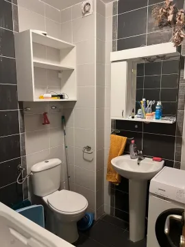 Manje kupatilo sa umivaonikom, WC šoljom i zidnim pločicama u kombinaciji sive i bijele boje. - image 8