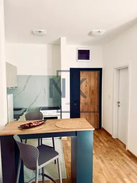 Dining table with chairs near the kitchen and front door. - image 3