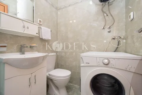 Compact bathroom with a washbasin, toilet, and washing machine. - image 5