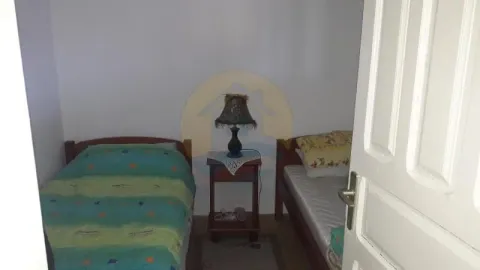 Bedroom with two single beds and a bedside table. - image 5