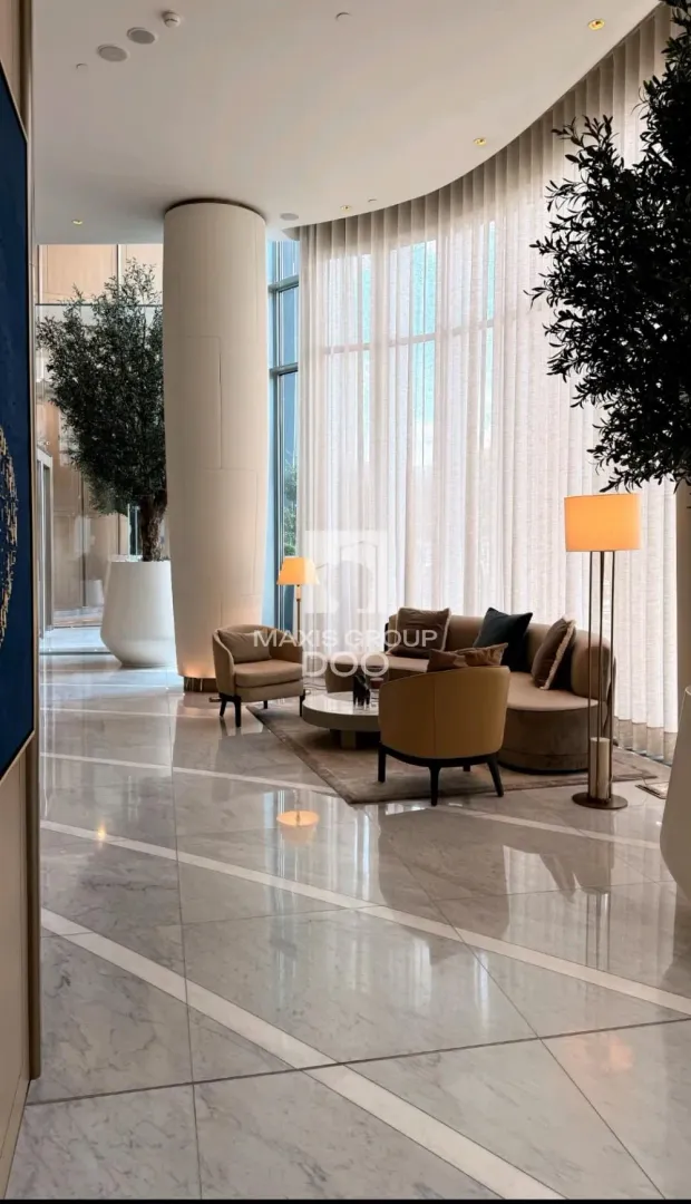 Spacious living room with comfortable seating sets and large windows.
