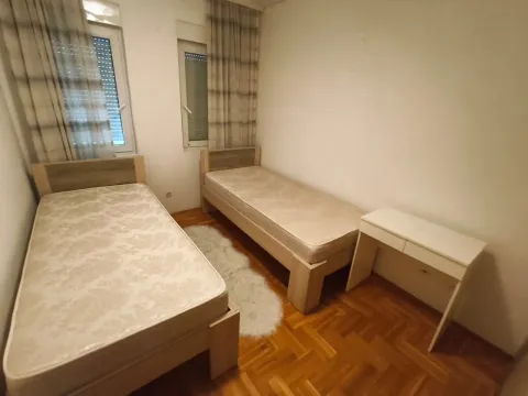 Bedroom with two single beds, a desk and windows. - image 6