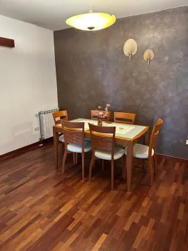Dining area with a wooden table and chairs, hardwood flooring, and a decorative accent wall. - image 6