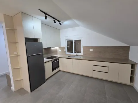 Moderna kuhinja sa ugradnim elementima i crnim frižiderom u potkrovlju. - image 5
