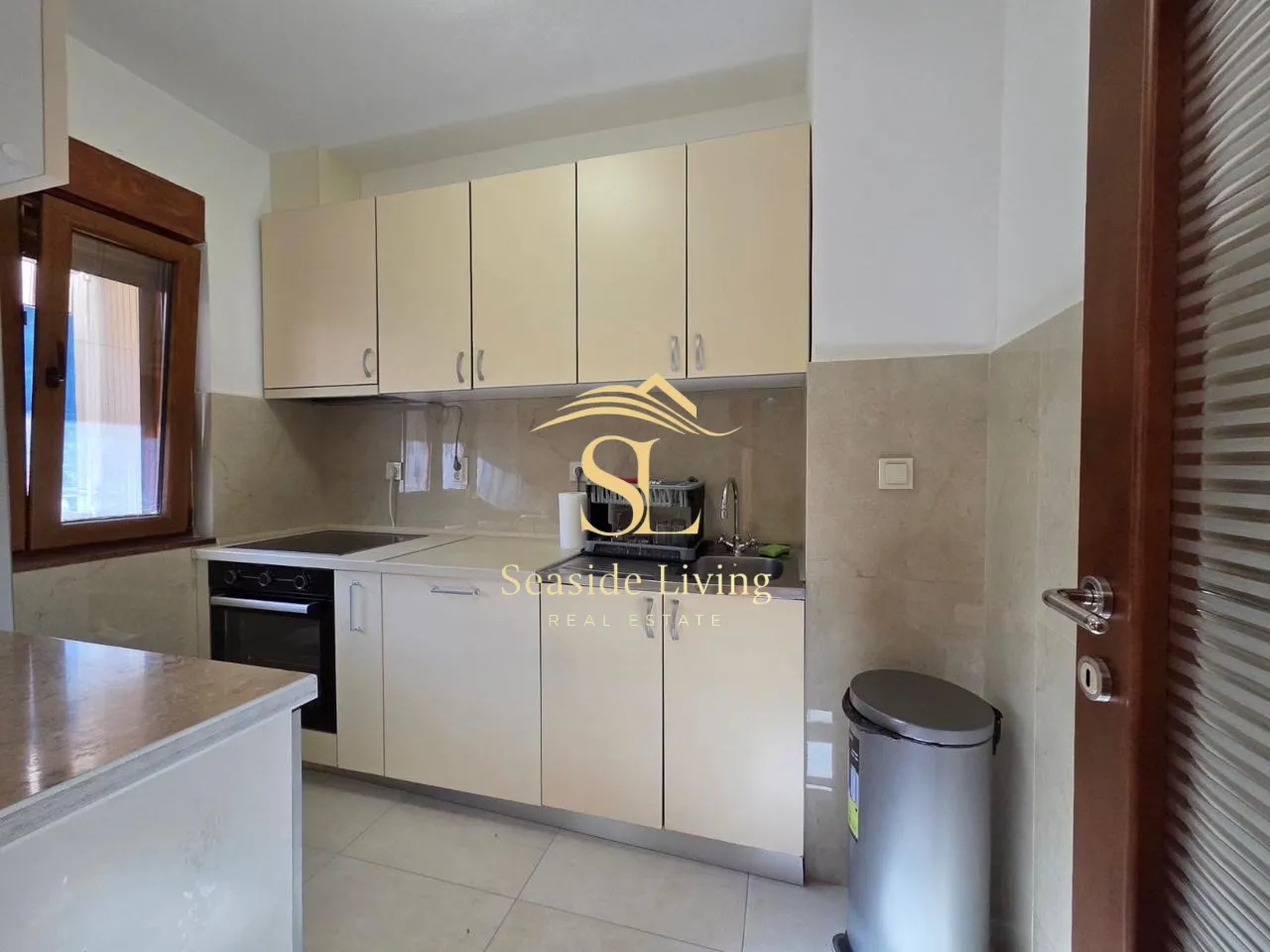 Small kitchen with light cabinetry and built-in oven.