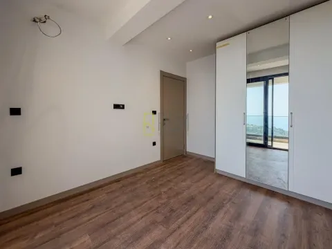 Svjetla spavaća soba sa ugradnim plakarom sa ogledalom i drvenim podom. - image 10