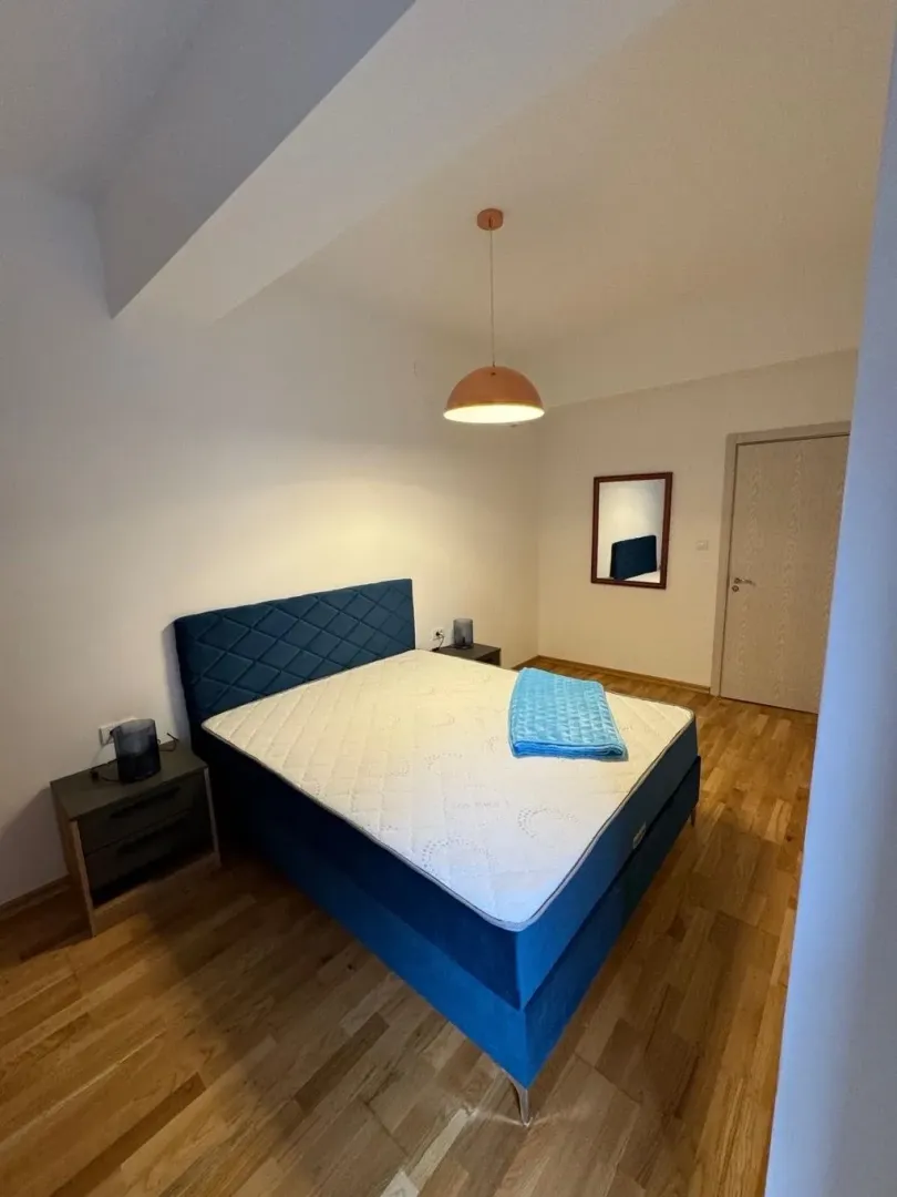 Bedroom with a double bed, bedside tables, and a pendant lamp.