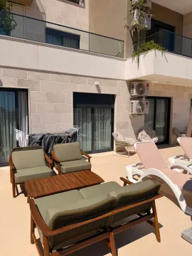 Spacious terrace with lounge furniture and sun loungers in front of the building. - image 12