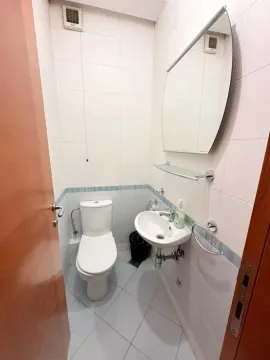 Manje kupatilo obloženo svijetlim pločicama sa toaletom i umivaonikom. - image 12