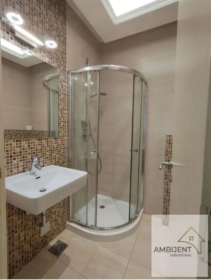 Modern bathroom with a shower cabin and a washbasin.