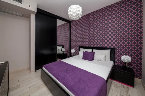 Moderna spavaća soba sa bračnim krevetom, crnim garderoberom sa ogledalom i ljubičastim tapetama. - image 6