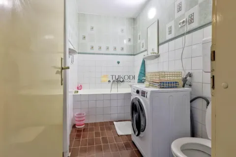 Bathroom equipped with a bathtub, washing machine, and toilet. - image 10