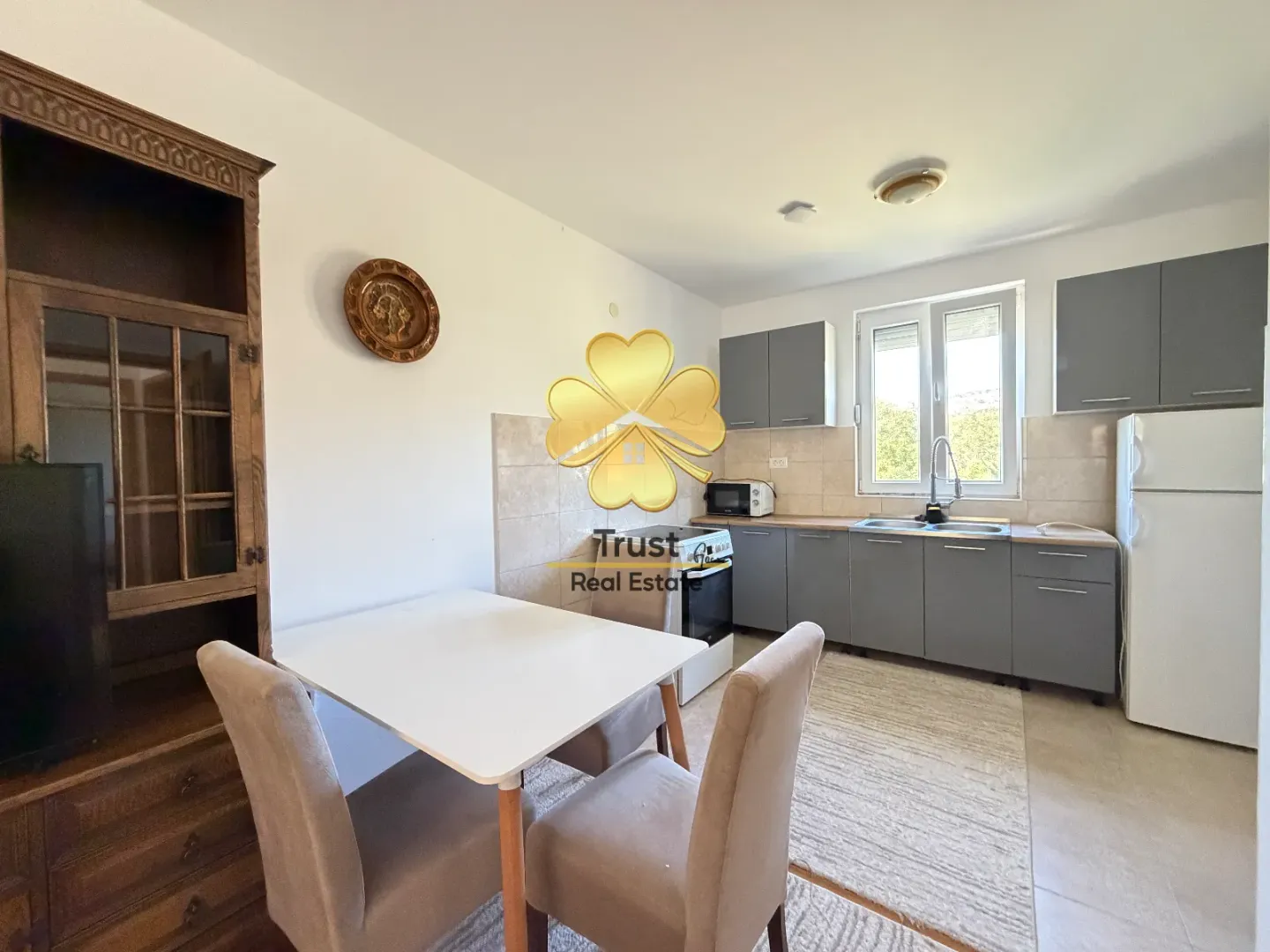 Kitchen with dining area and grey units.