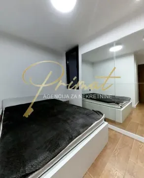Nameštena spavaća soba sa bračnim krevetom i velikim ogledalom na zidu. - image 13