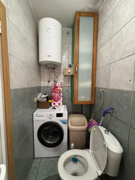 Bathroom with washing machine, water heater, and toilet. - image 15