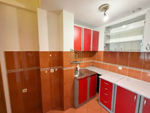 Kuhinja sa crvenim elementima i keramičkim pločicama na zidu. - image 7
