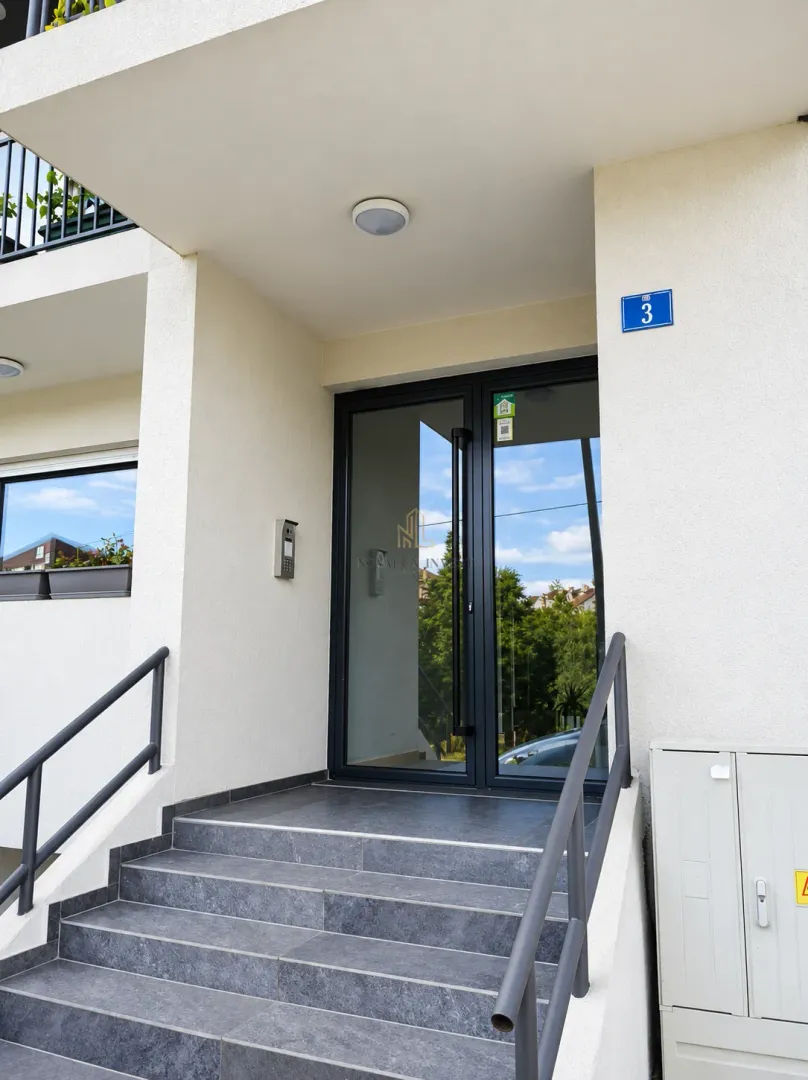 Building entrance with stairs and glass doors.
