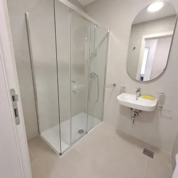 Savremeno opremljeno kupatilo sa tuš kabinom i umivaonikom. - image 6