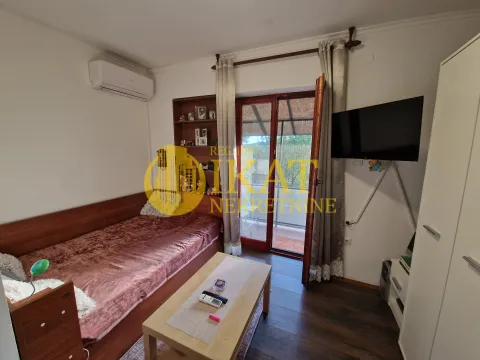 Nameštena spavaća soba sa krevetom, TV-om i izlazom na terasu. - image 7