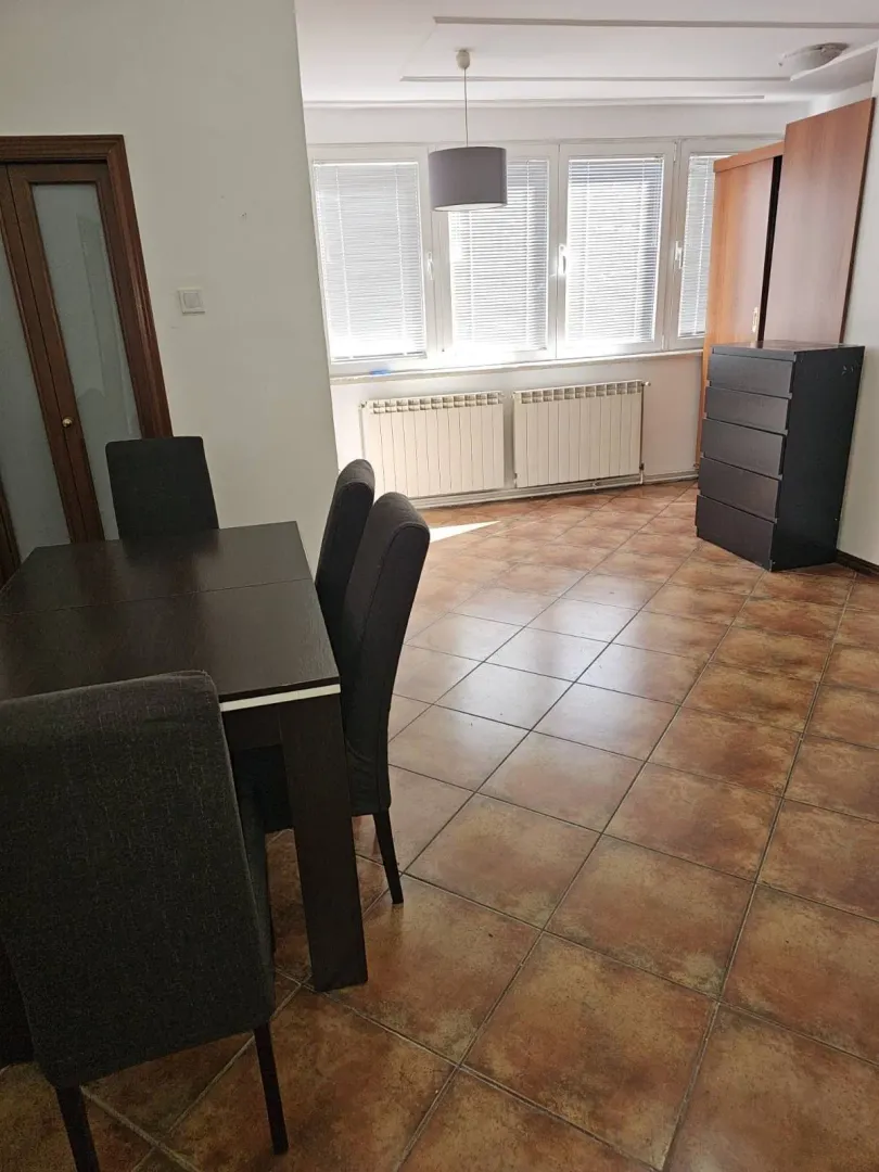 Trpezarijski sto sa stolicama u svijetloj prostoriji sa pločicama.