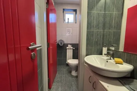 View of the bathroom with a sink in the foreground and a toilet in the background. - image 14