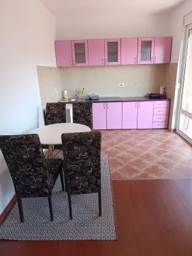 Kitchen with dining area and pink cabinets. - image 13