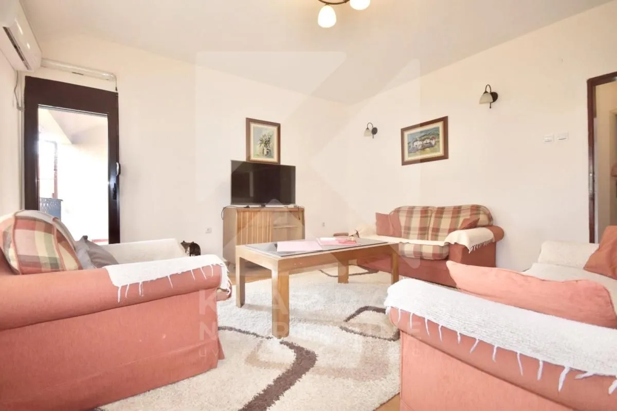 Living room furnished with a sofa set, coffee table, and television.