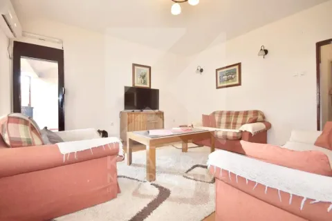 Living room furnished with a sofa set, coffee table, and television. - image 2