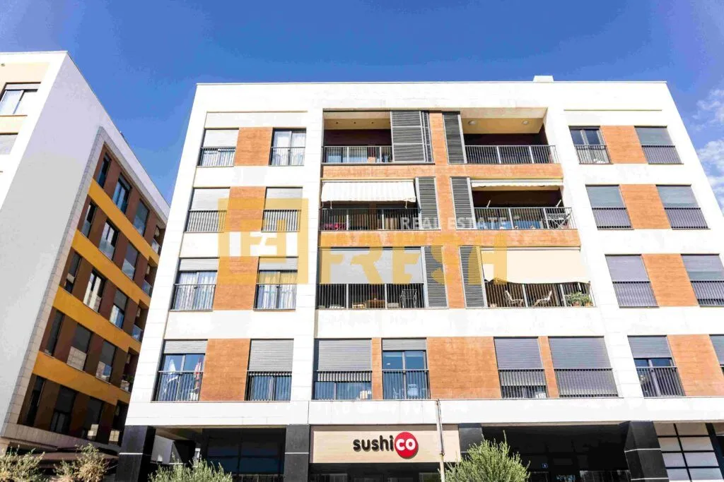 View of the exterior of a modern residential building with commercial space on the ground floor.