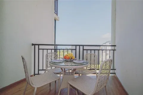 Covered terrace with a dining table, chairs, and a view of the surroundings. - image 9